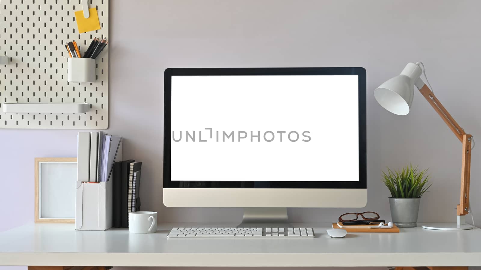 Creative Workspace. White blank screen computer on Office working desk. Equipment on table.