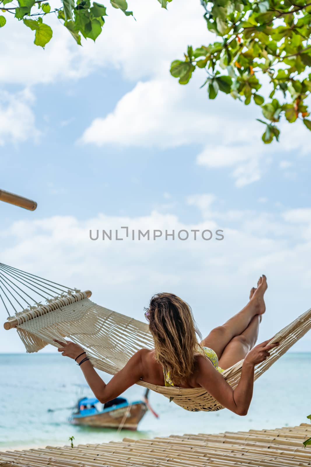 Woman relaxing at the beach on a hammock