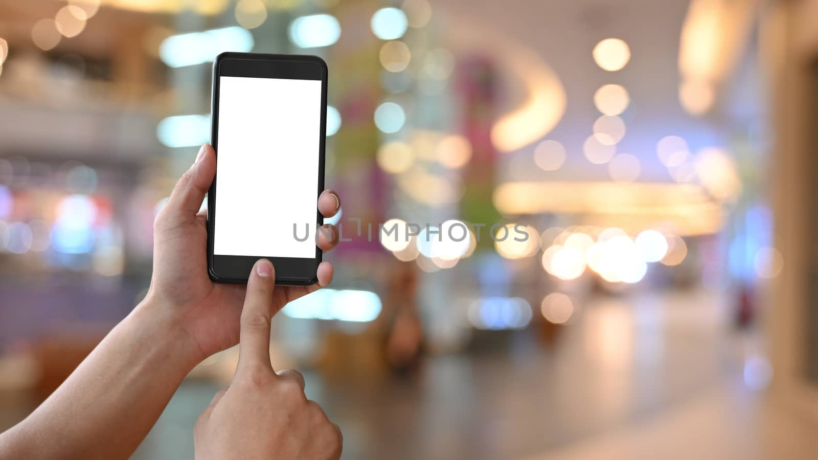 Close-up image of hand while holding crop black smartphone with  by prathanchorruangsak