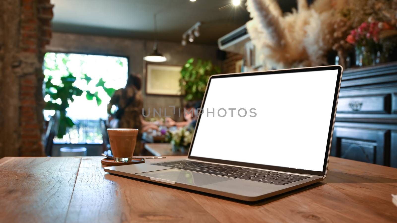 Mockup Laptop and coffee cup putting together on the wooden table with the beautiful classic decorate room as background.