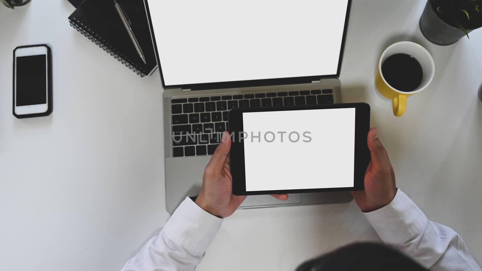 Top view image of business man holding a white blank screen tabl by prathanchorruangsak