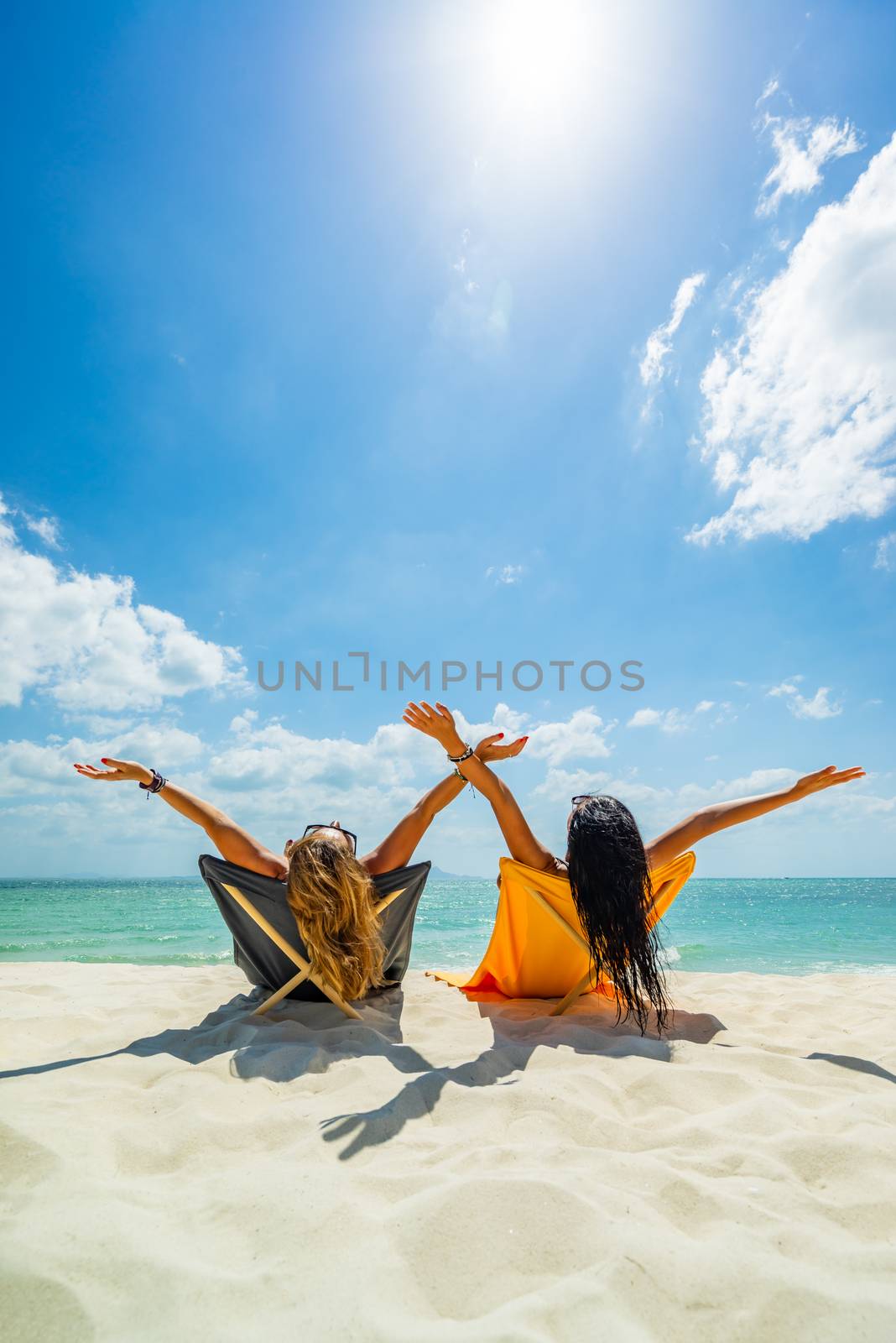 Women enjoying their holidays on a transat at the tropical beach in Thailand