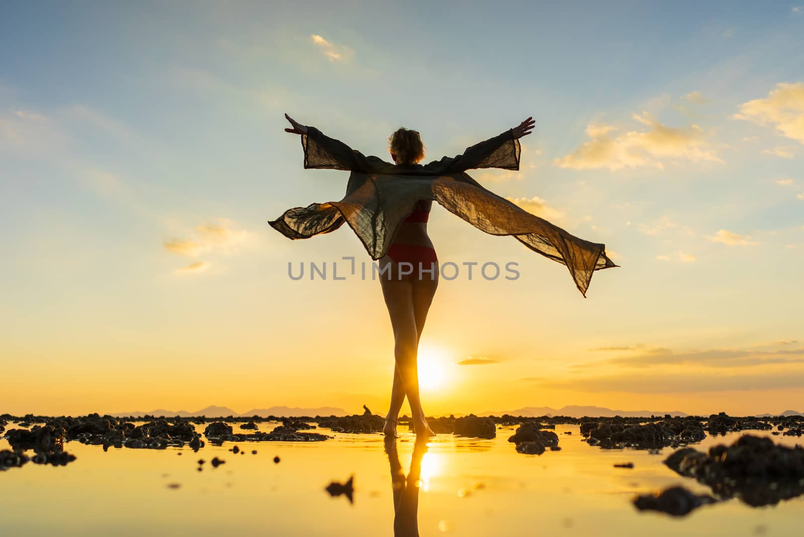 Woman on the beach at sunset by Netfalls