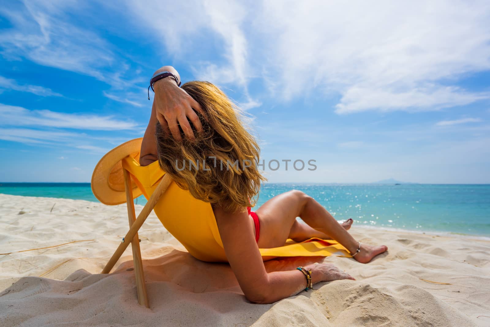 Woman enjoying her holidays on a transat at the tropical beach in Thailand