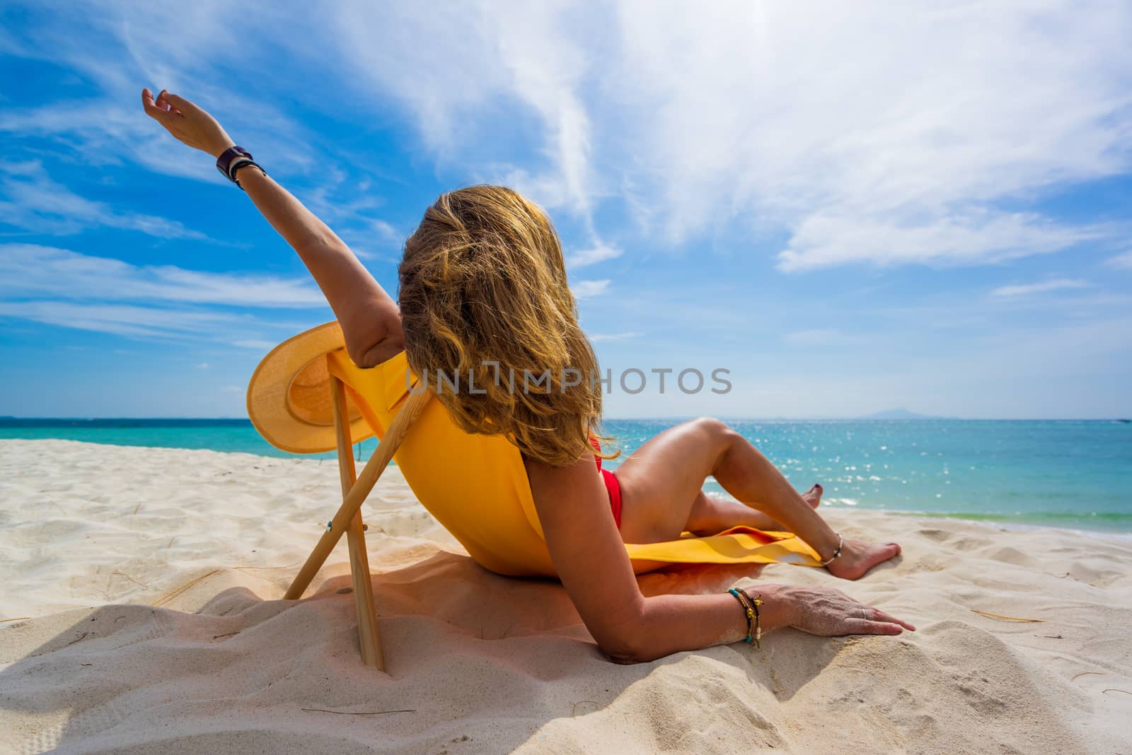 Woman enjoying her holidays on a transat at the tropical beach in Thailand