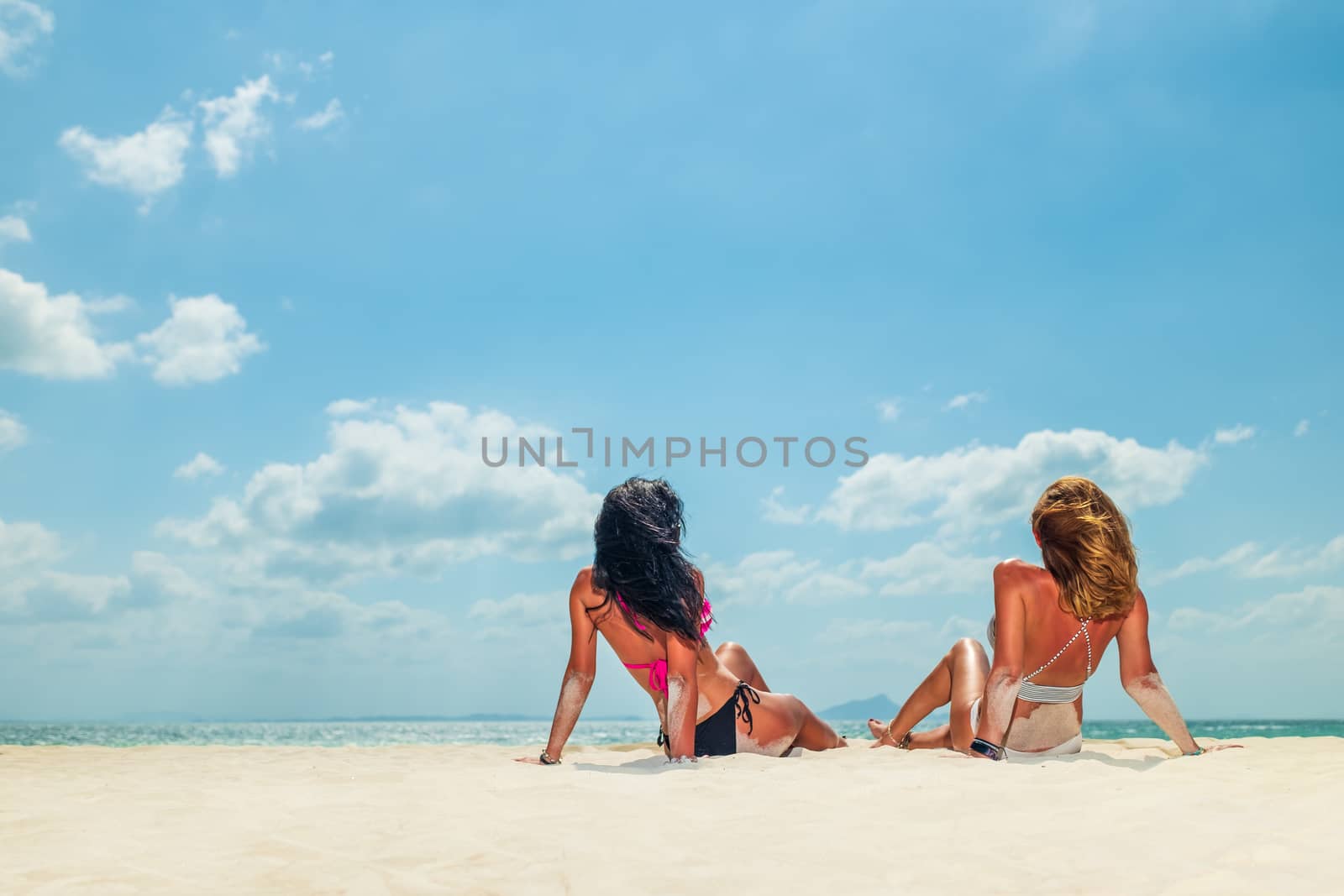 Two Women enjoying their holidays on the tropical beach  by Netfalls