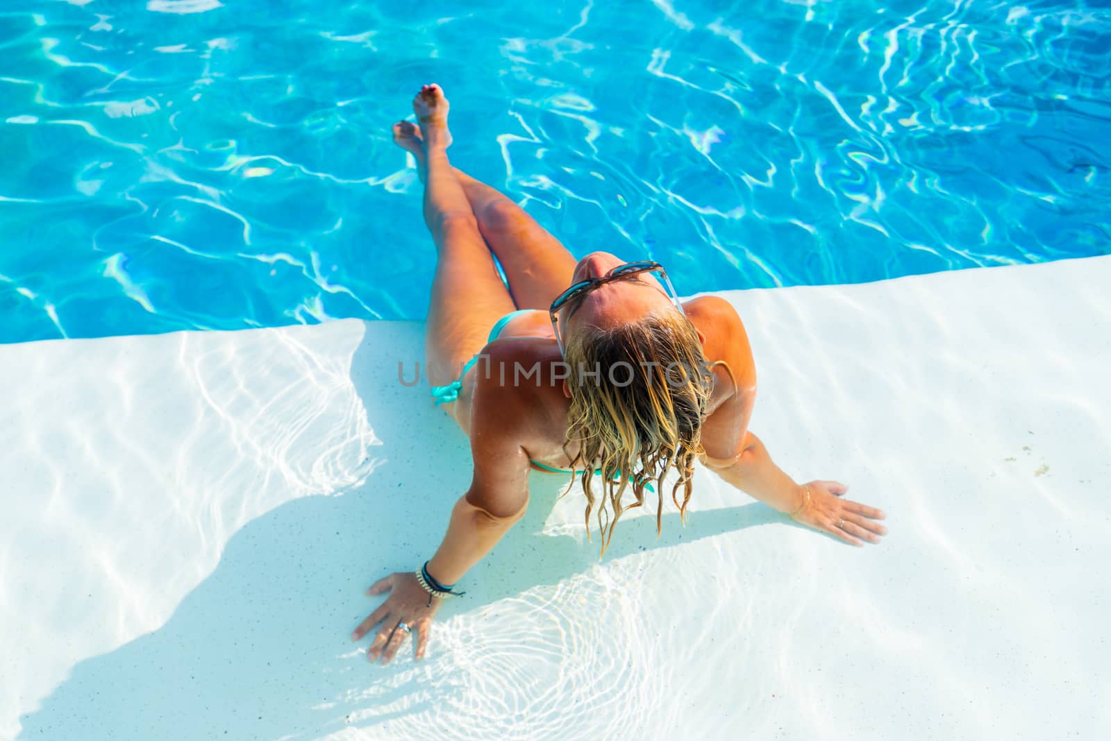 Woman relaxing at the swimming pool at the luxury tropical resort