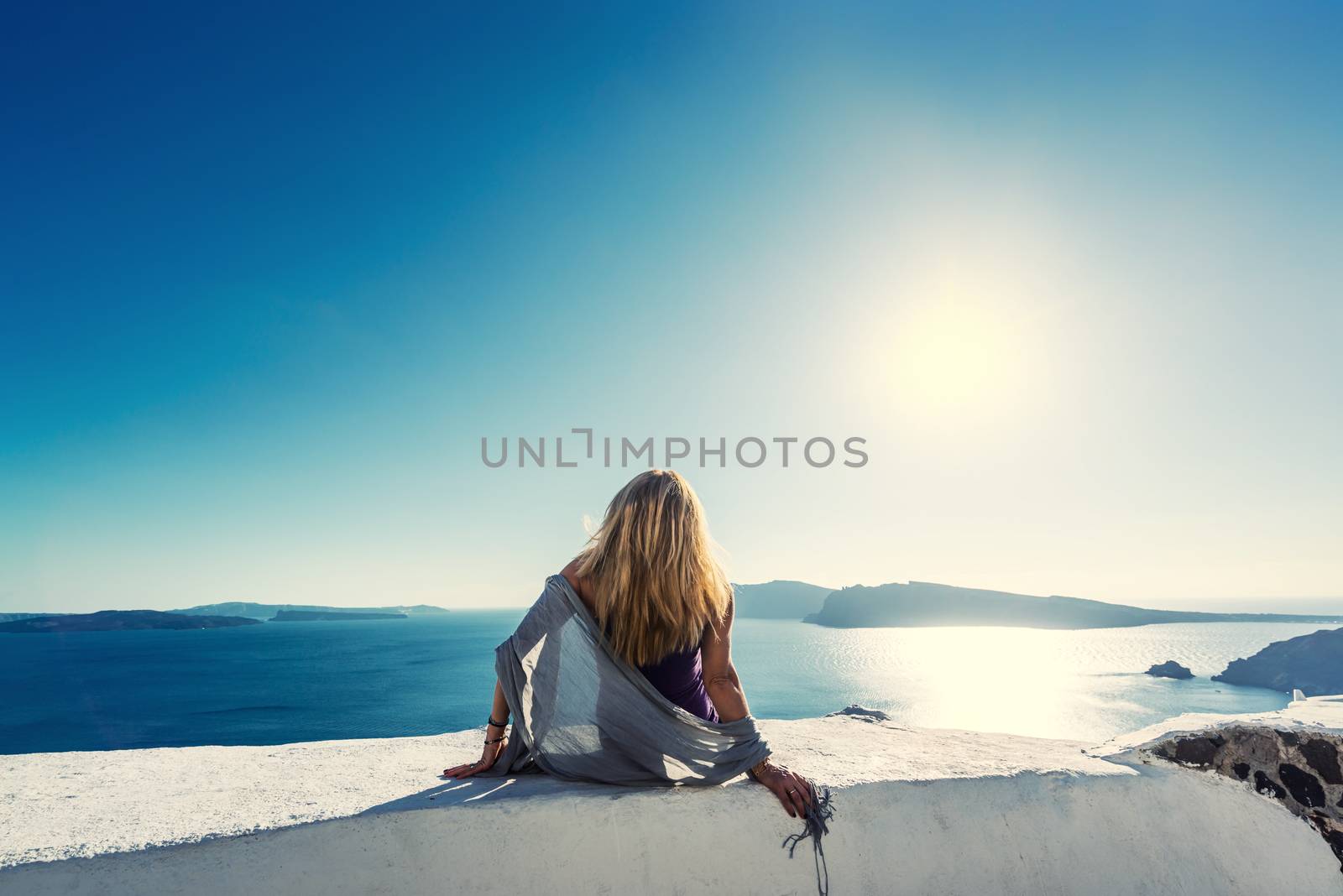 Luxury travel vacation woman looking at view on Santorini island in Greece. Amazing view of sea and Caldera.
