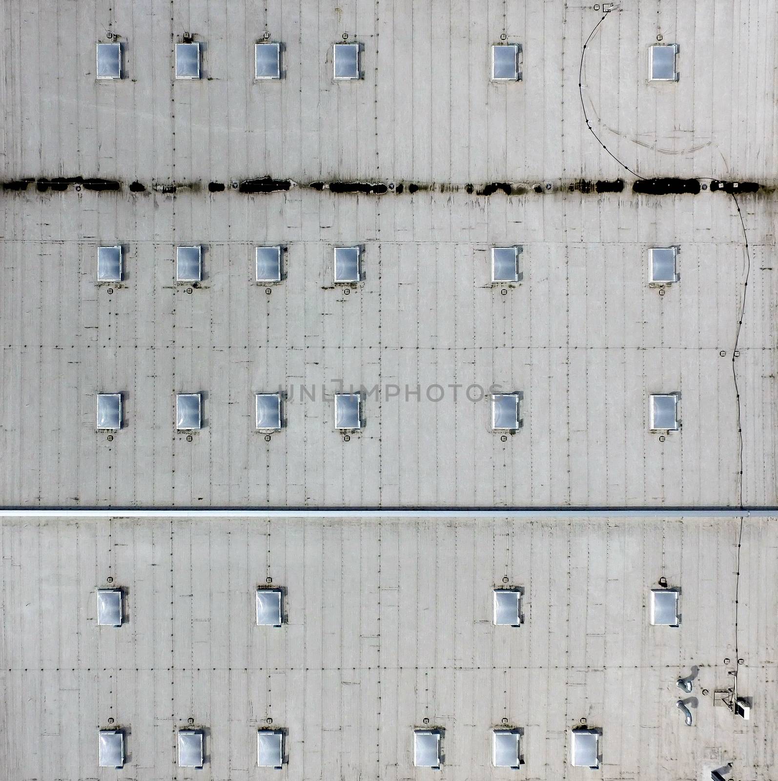 Aerial view of the flat roof of an industrial hall, as background, made with drone