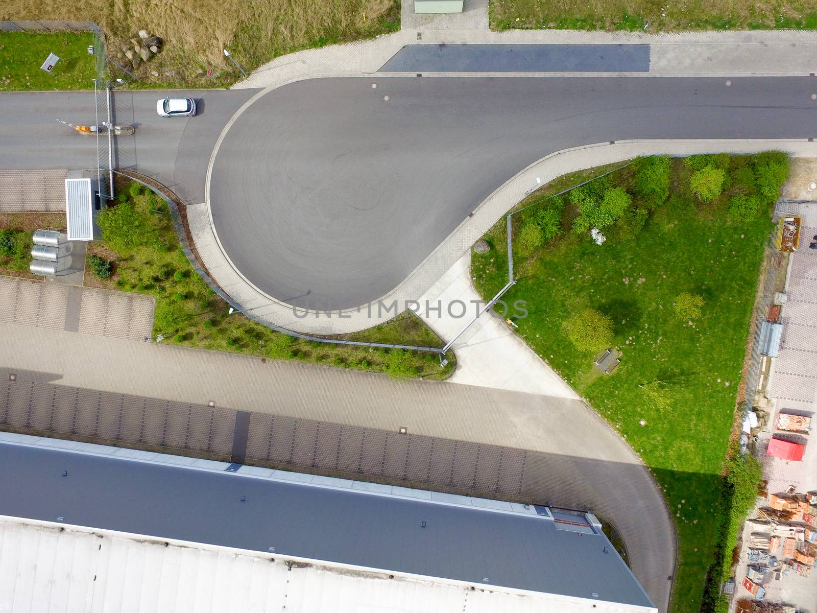 Abstract vertical aerial view of a turning loop in front of the barrier with access to a company premises, made with drone