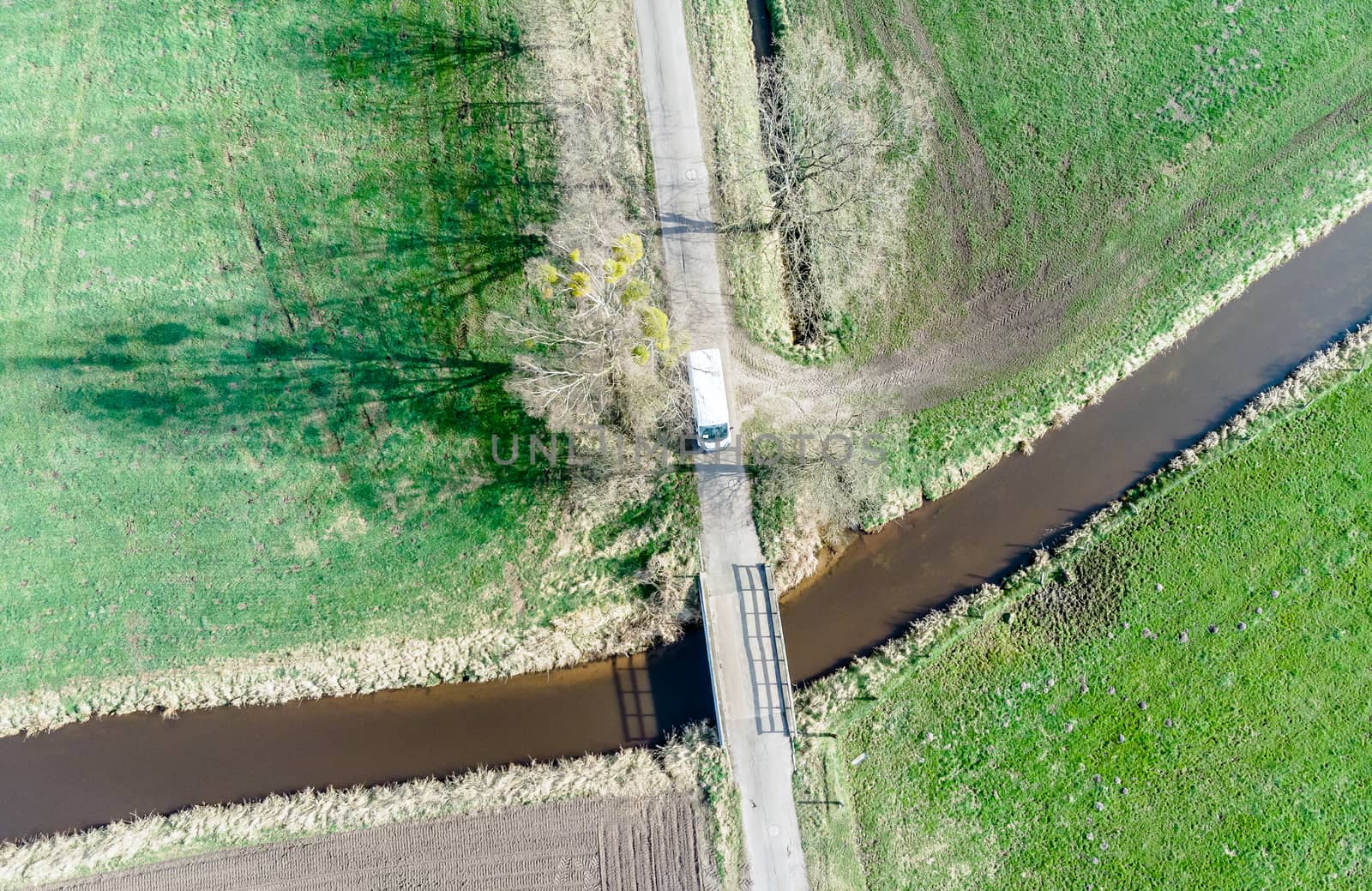 Aerial view of a stream flowing through meadows and fields under by geogif