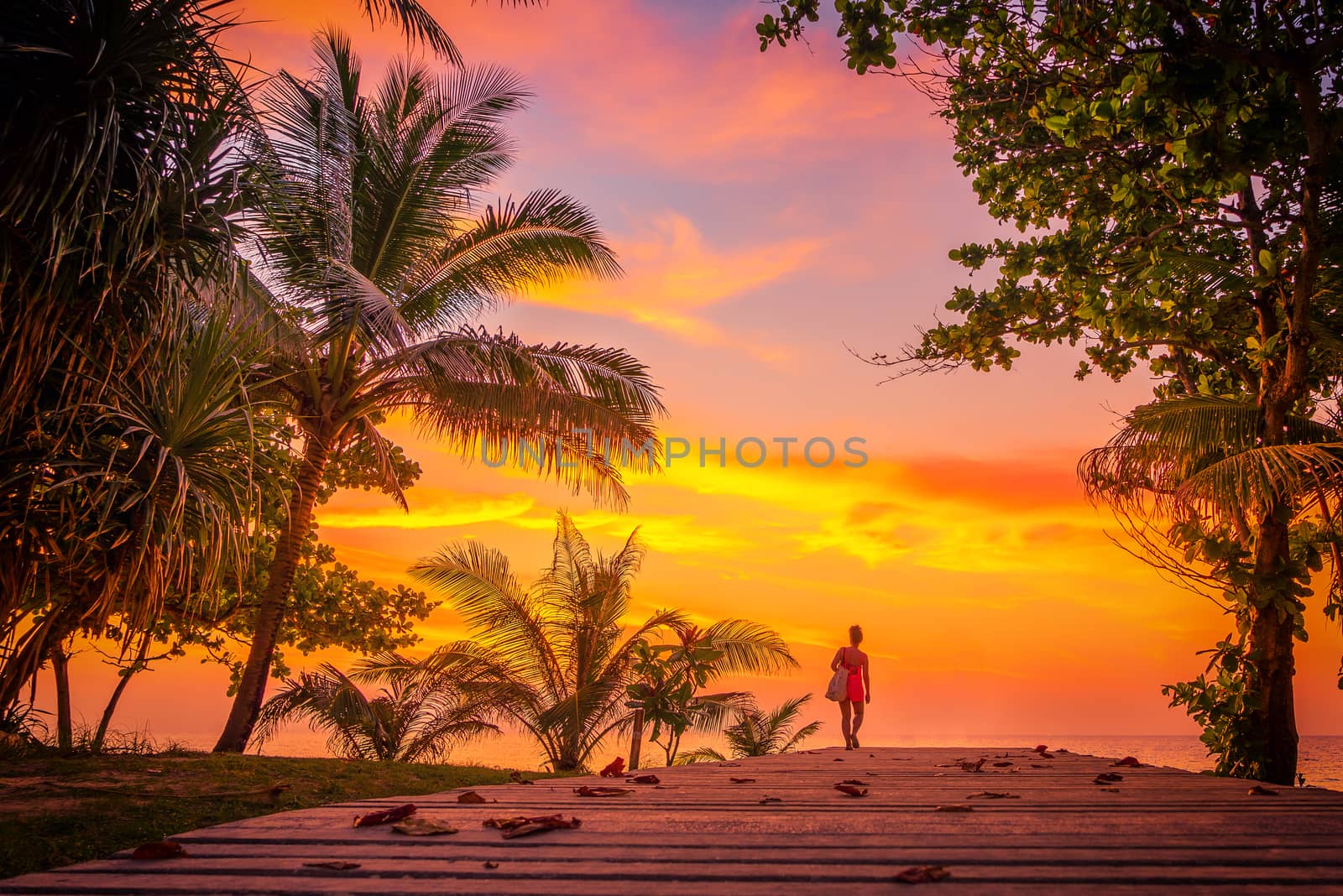 Woman on the bach at Sunset on Karon beach Phuket Thailand