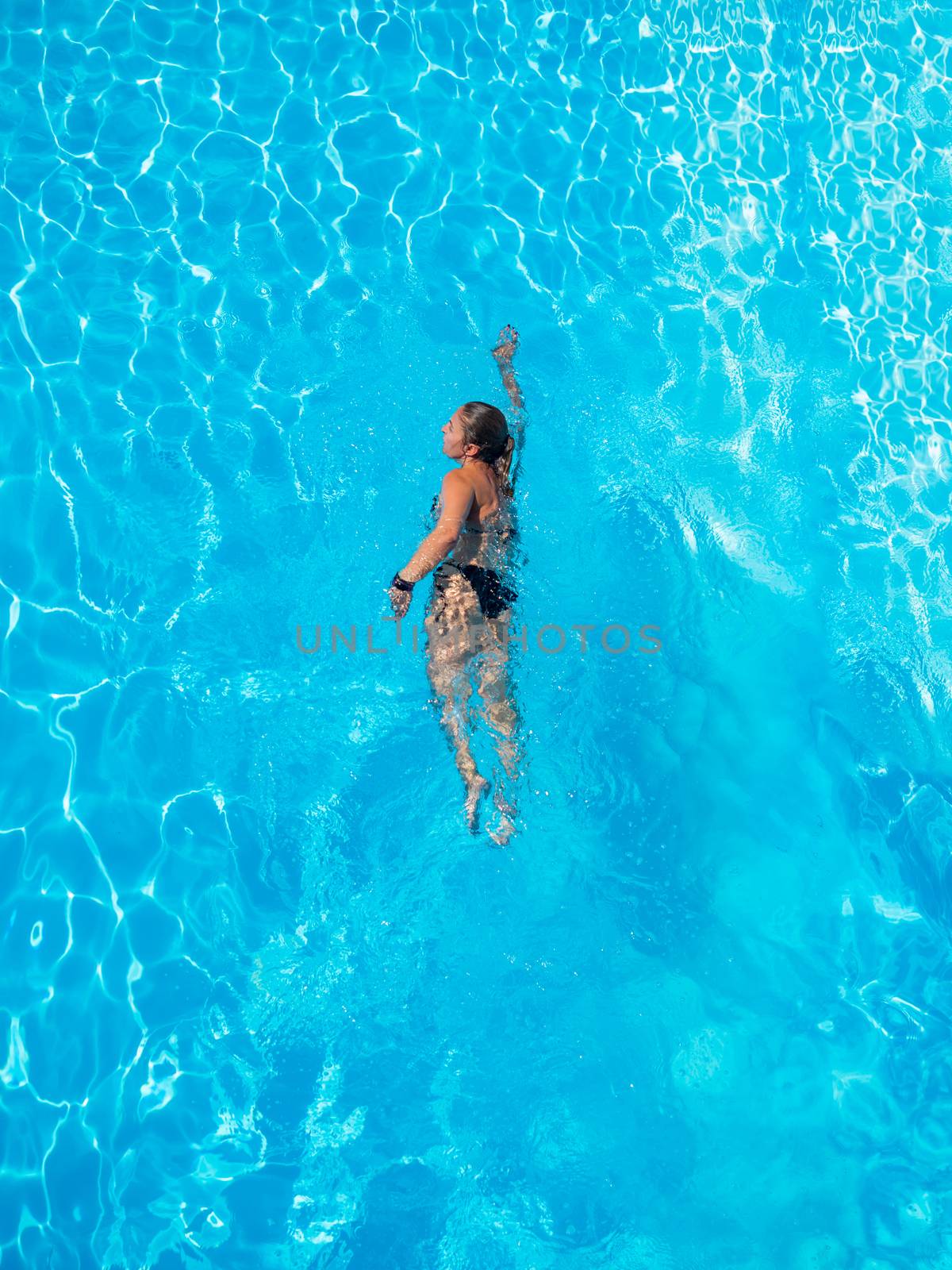 Top view of a woman swimming in the pool