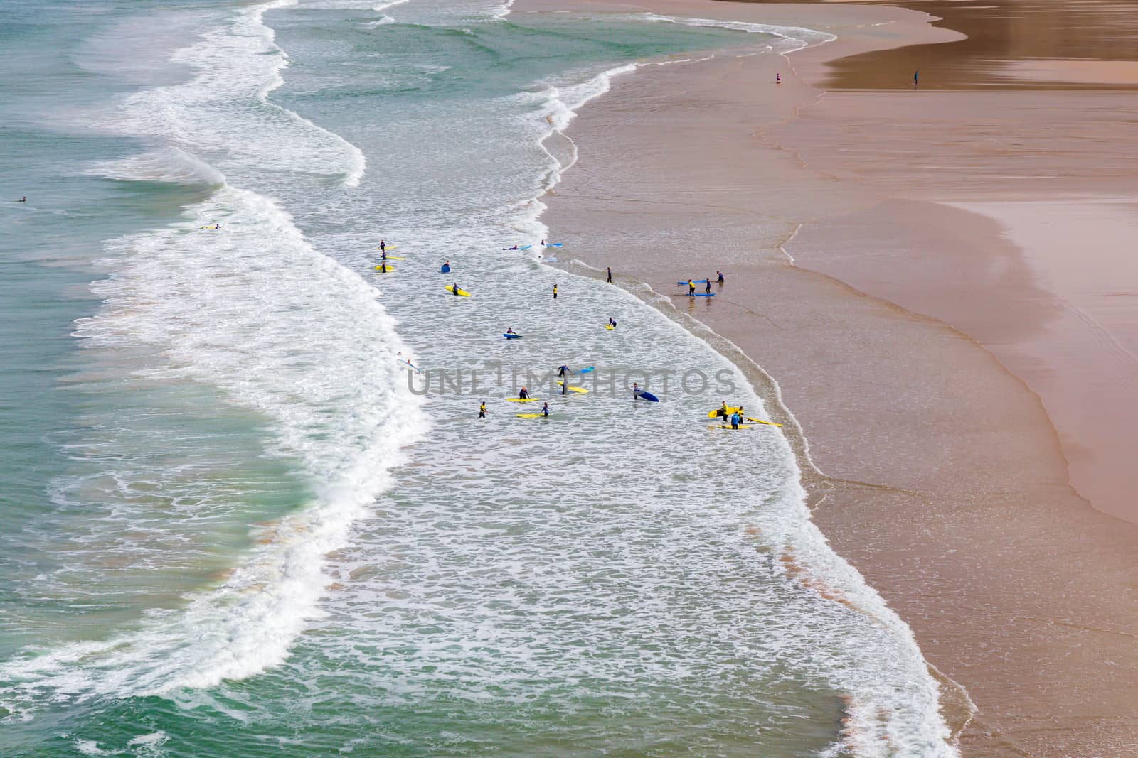 Surfers in the waves off Mawgan Porth Beach, Cornwall, UK