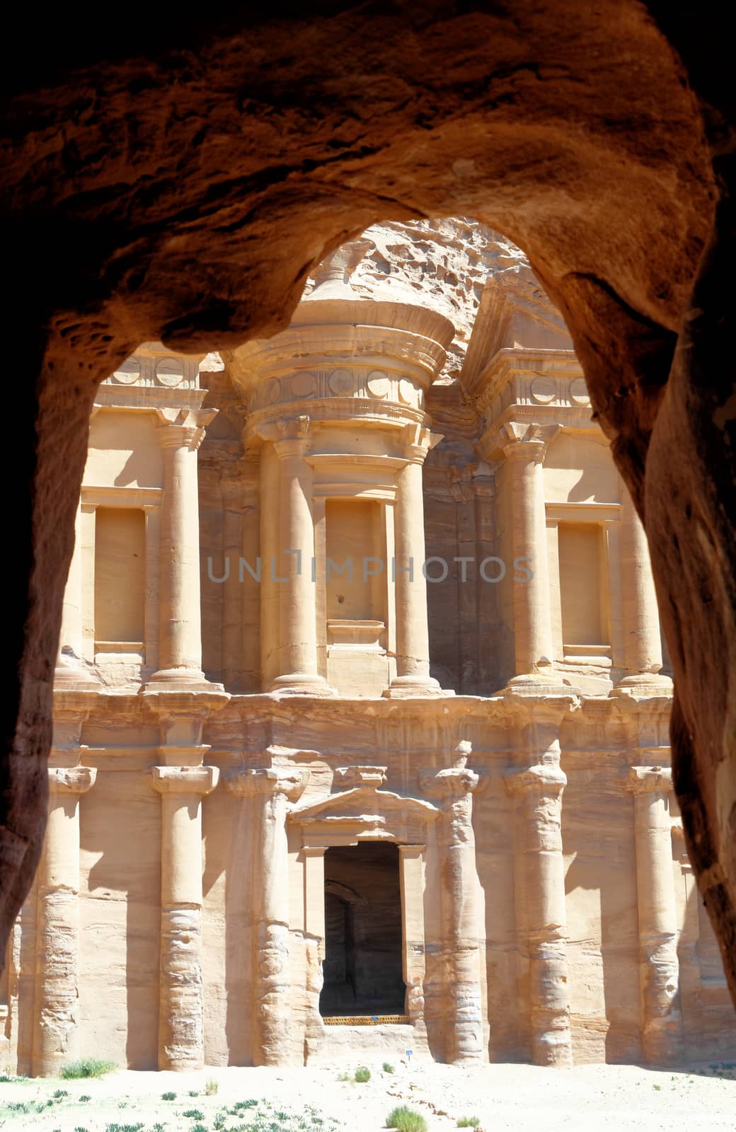 The Al-Deir Monastery in the mountains of Petra, Jordan, framed by the rocks of a cave, middle east