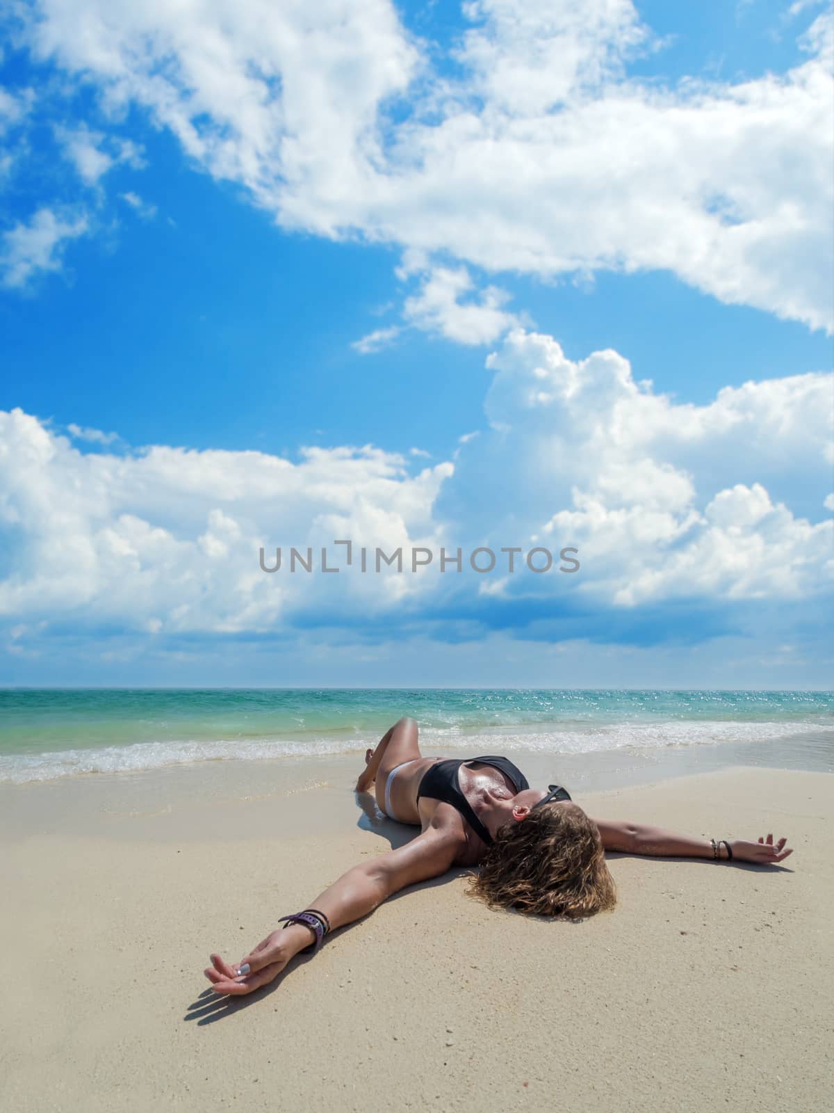 woman sunbathing lying down on the tropical beach summer travel holidays