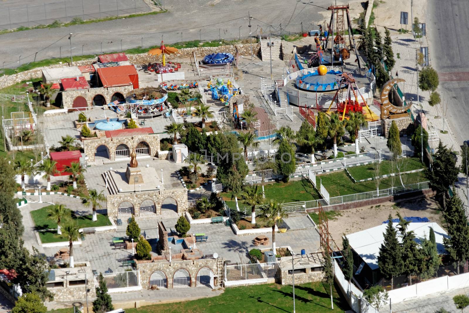 View from above of a small amusement park with play equipment for children on the edge of Karak, Jordan by geogif