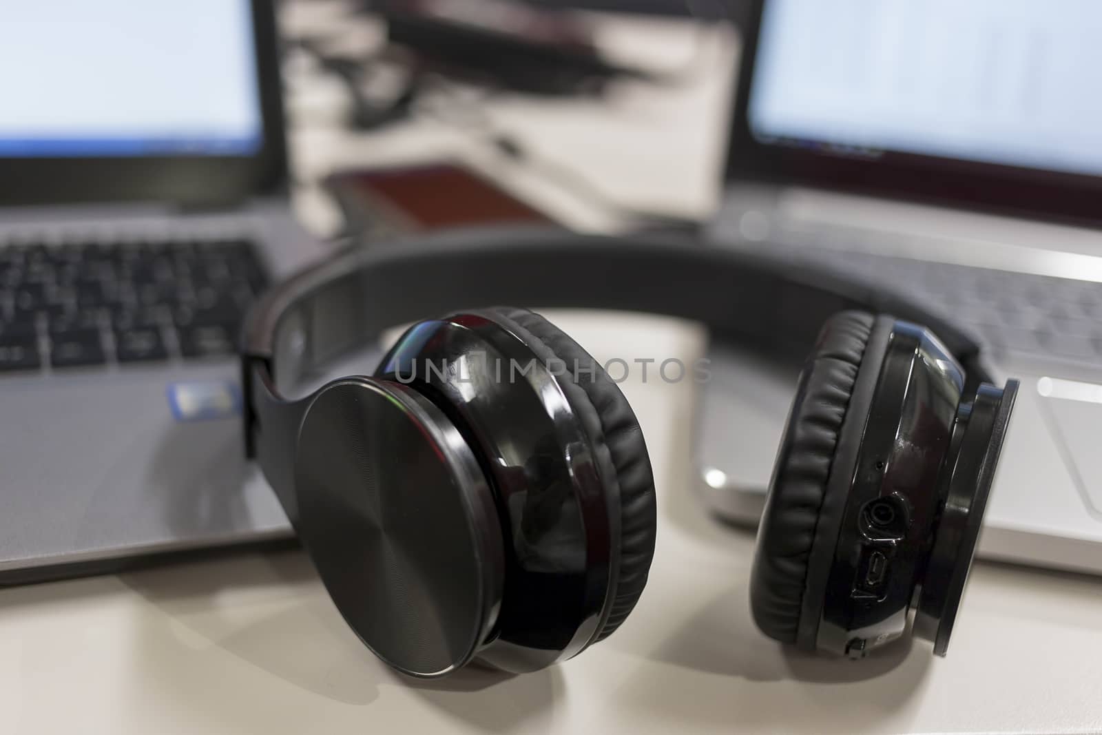 Laptops and bluetooth headphones in an office environment  by magicbones