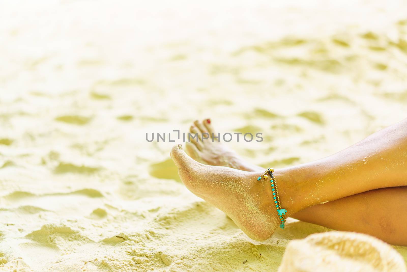 Woman feet leg near beach sand red nails 