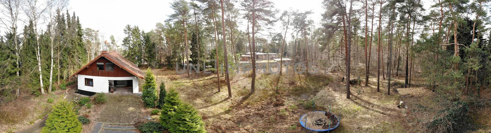 Composite panorama from aerial photos with a drone in low heights, detached house from the seventies on a forest property, old broken trampoline for the children by geogif