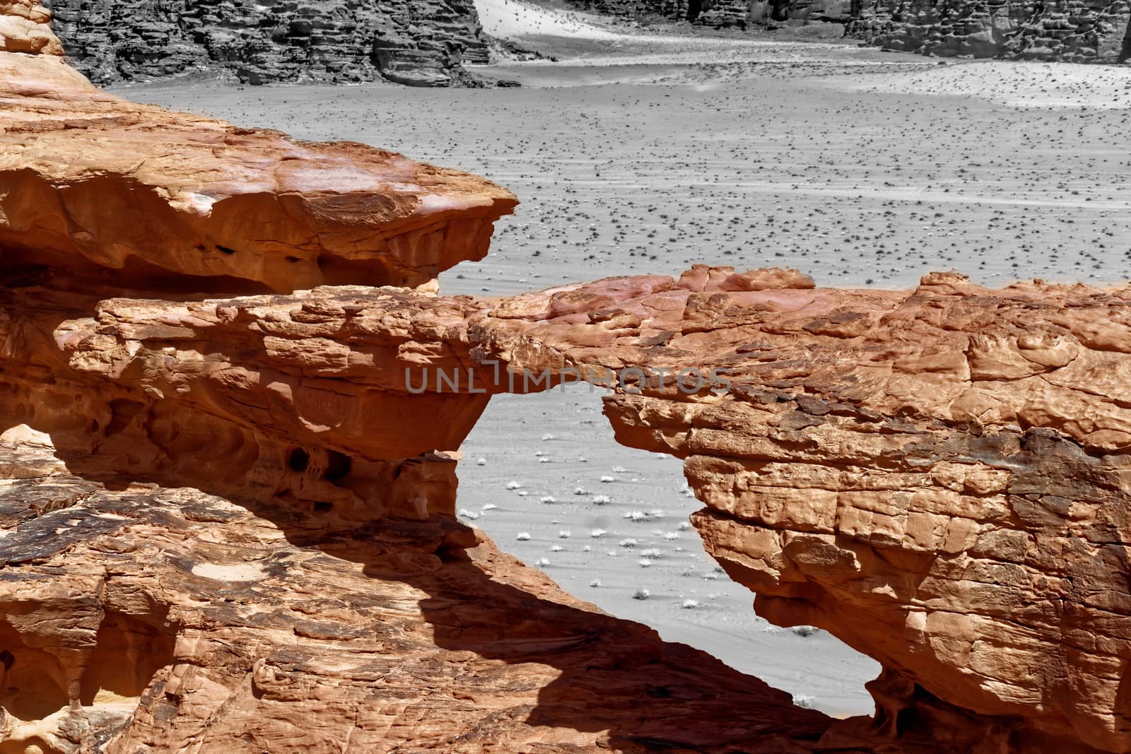 Stone bridge formed by erosion, with black and white alienated background and abstract effect, in the nature reserve of Wadi Rum, Jordan by geogif