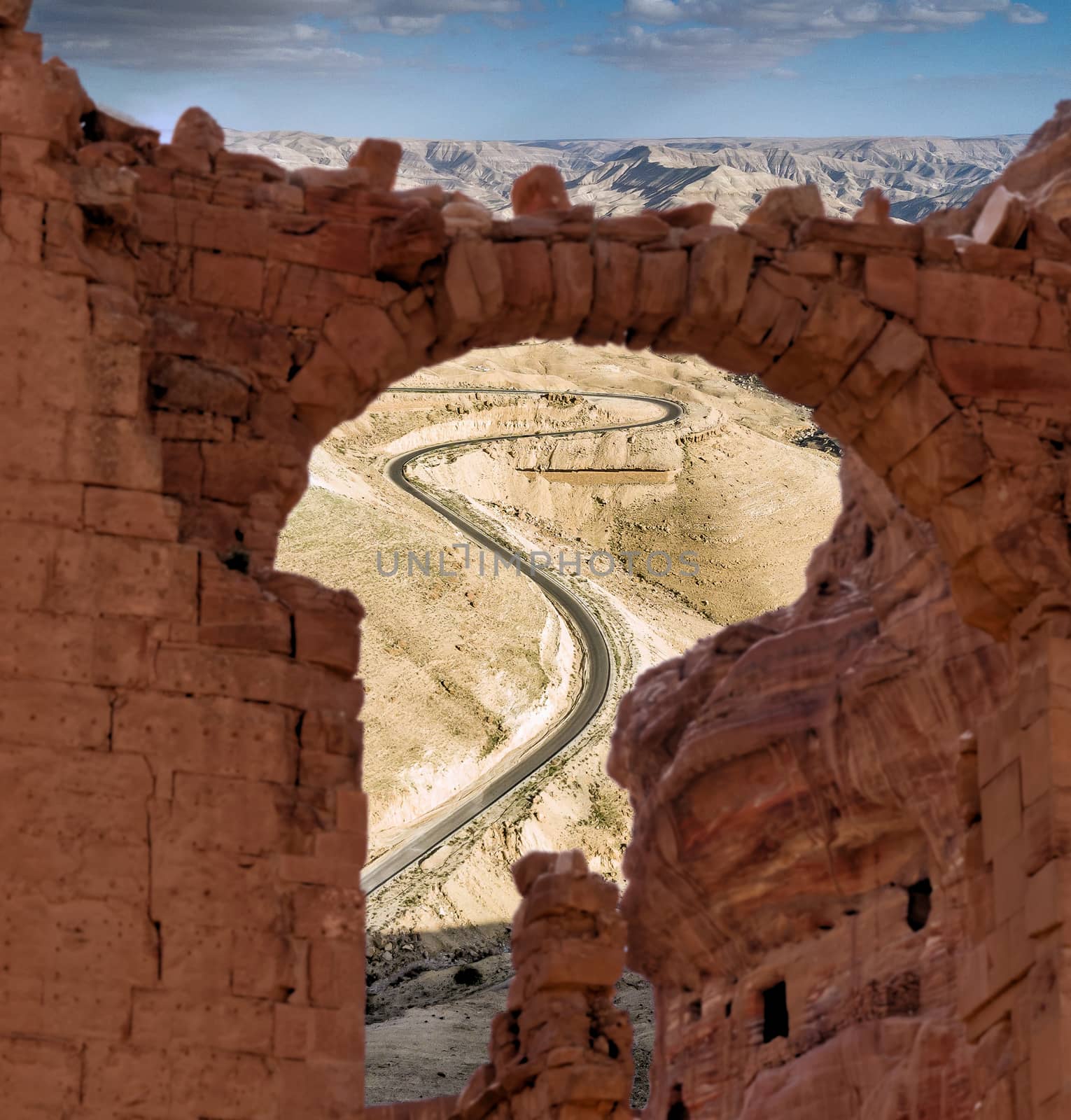 View through a ruin to a steep road with serpentines in the highlands of Jordan by geogif