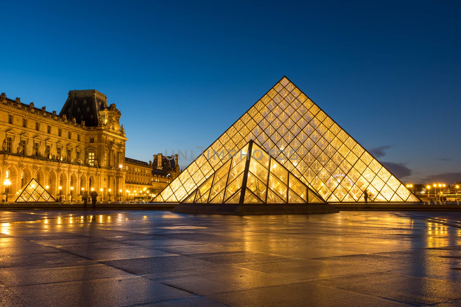 PARIS, FRANCE - DECEMBER 02, 2017: View of famous Louvre Museum with Louvre Pyramid at evening. Louvre Museum is one of the largest and most visited museums worldwide