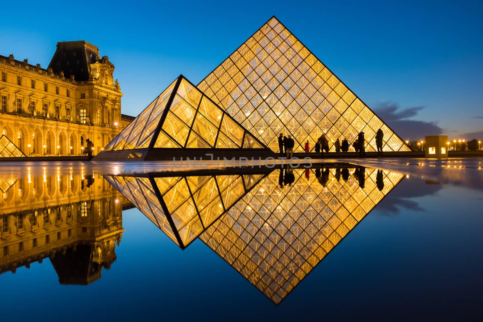 PARIS, FRANCE - DECEMBER 08, 2017: View of famous Louvre Museum with Louvre Pyramid at evening. Louvre Museum is one of the largest and most visited museums worldwide