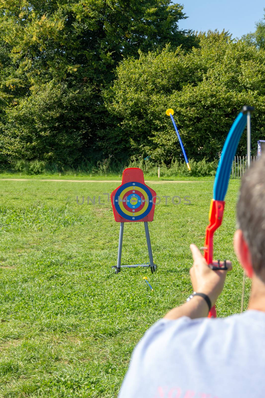 Man playing with a toy archery set in a field