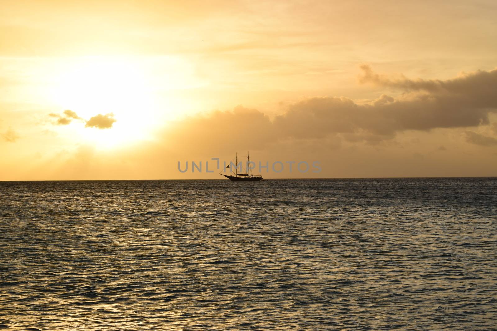 Beautiful golden sunset on the white beach of Aruba with turquoise water