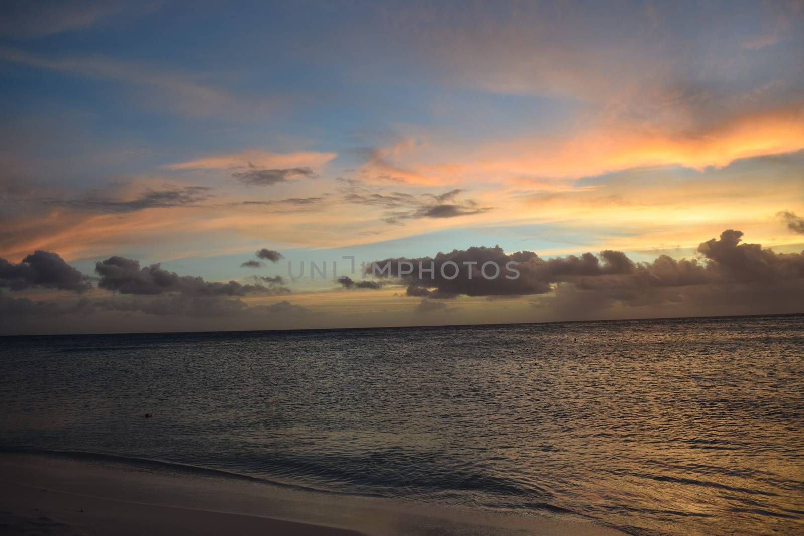 Beautiful golden sunset on the white beach of Aruba with turquoise water - Caribbean sunset - Real colours, no filters by matteobartolini