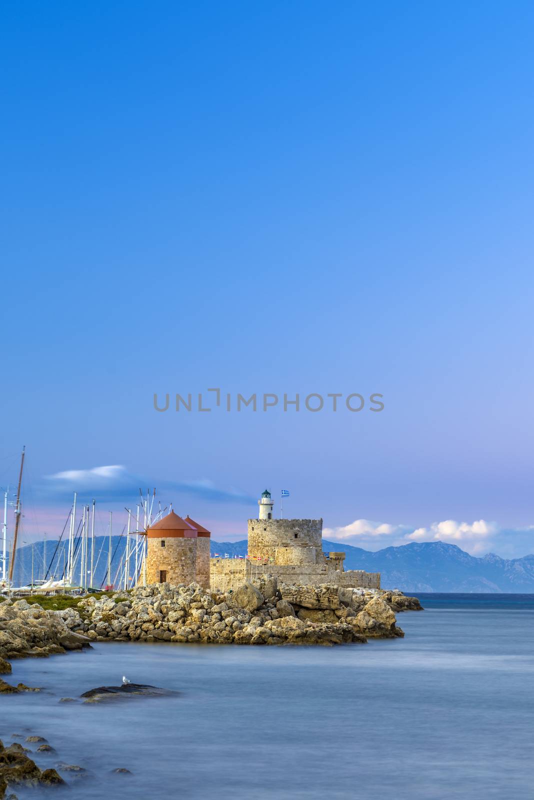 Agios Nikolaos fortress on the Mandraki harbour of Rhodes Greece at sunset