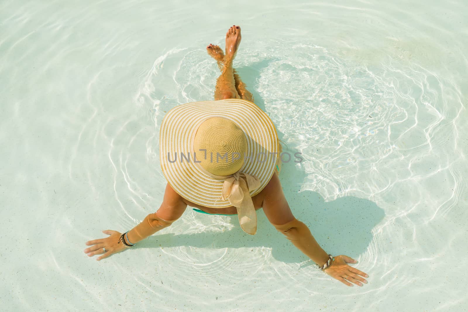 Woman with hat at the swimming pool