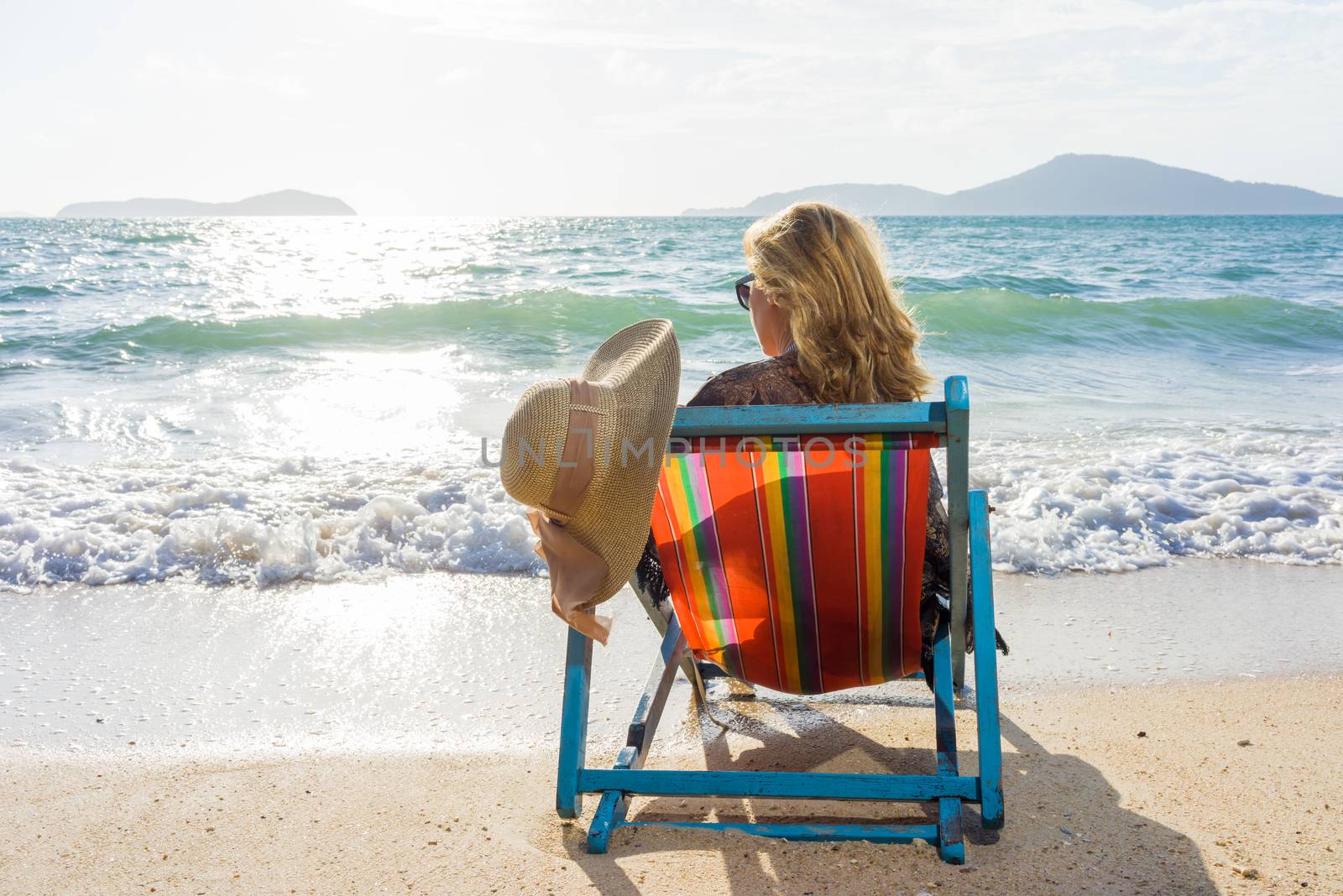 Beautiful woman sunbathing in a bikini on a beach at tropical travel resort enjoying summer holidays