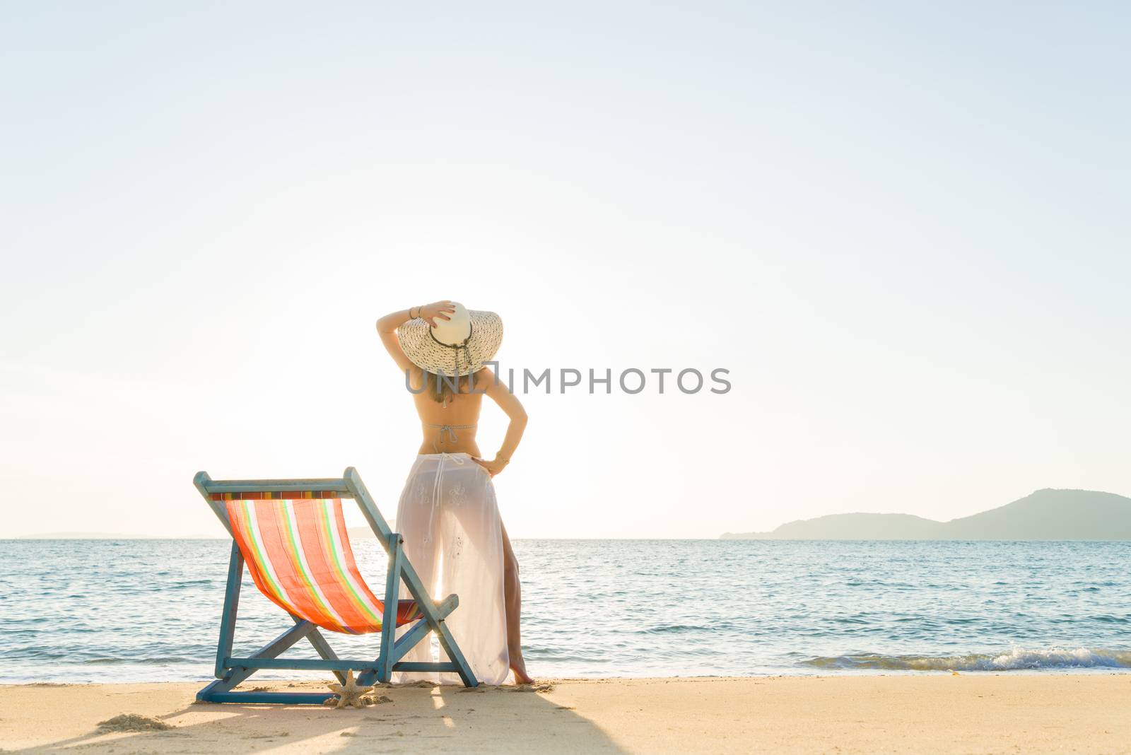 Young woman lying on sun lounger near the sea by Netfalls