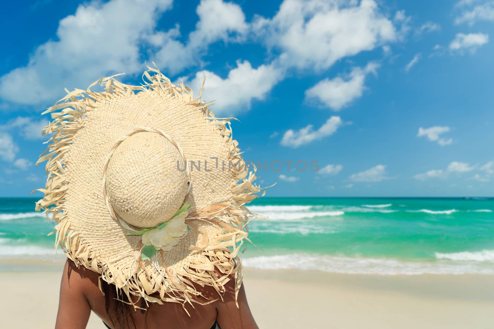Woman with hat chilling out on the beach