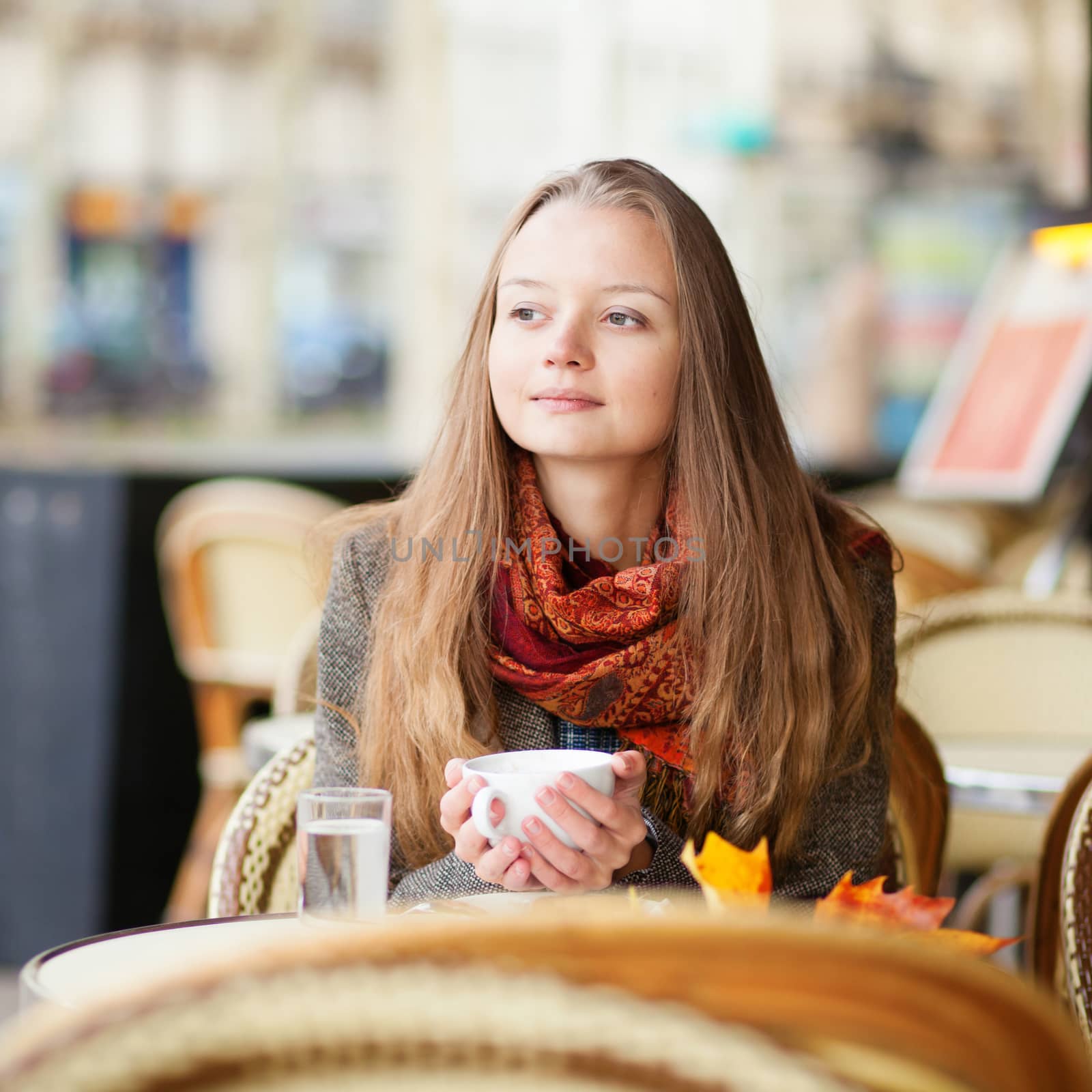 Pensive girl in a Parisian outdoor cafe