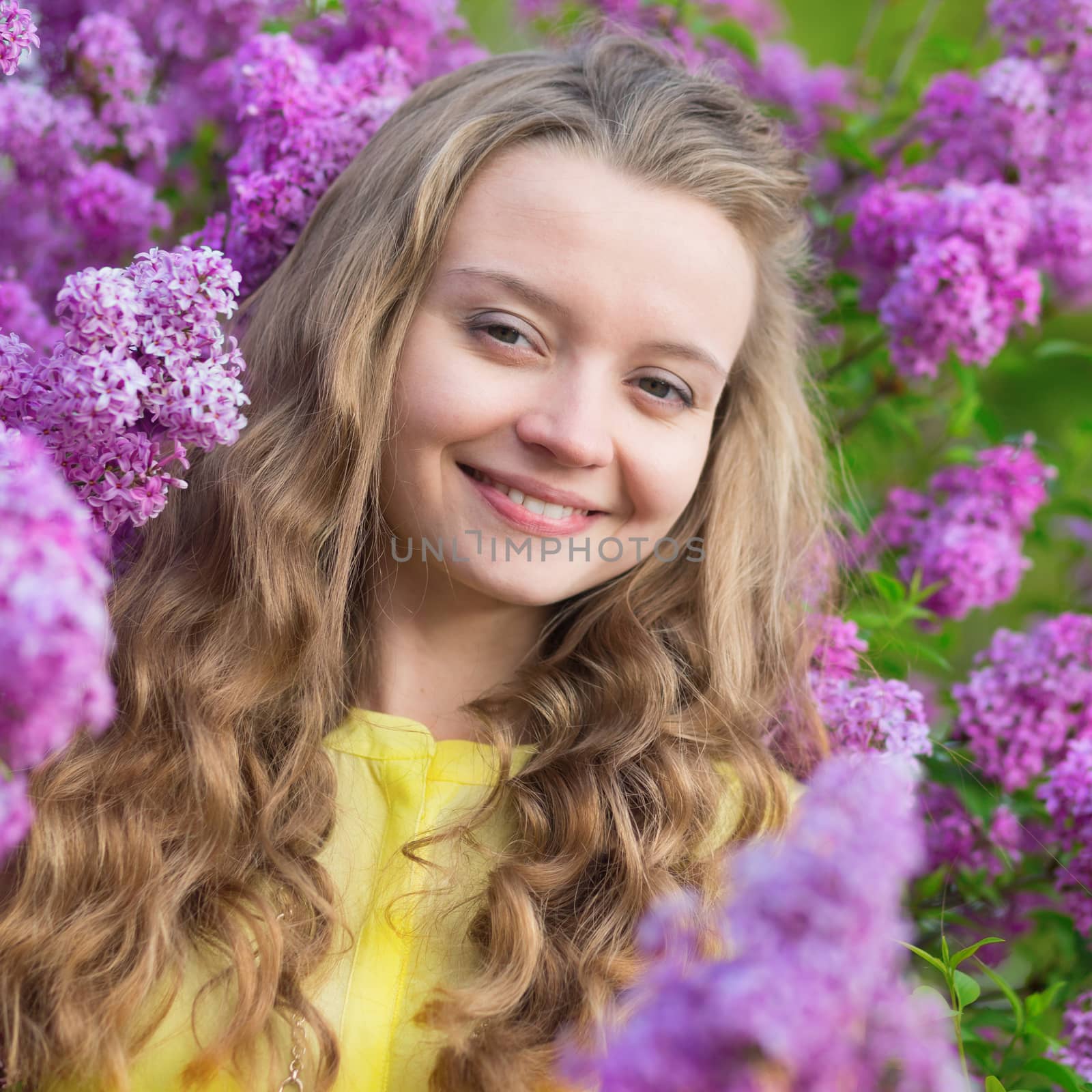 Smiling young girl with lilac blossom by jaspe