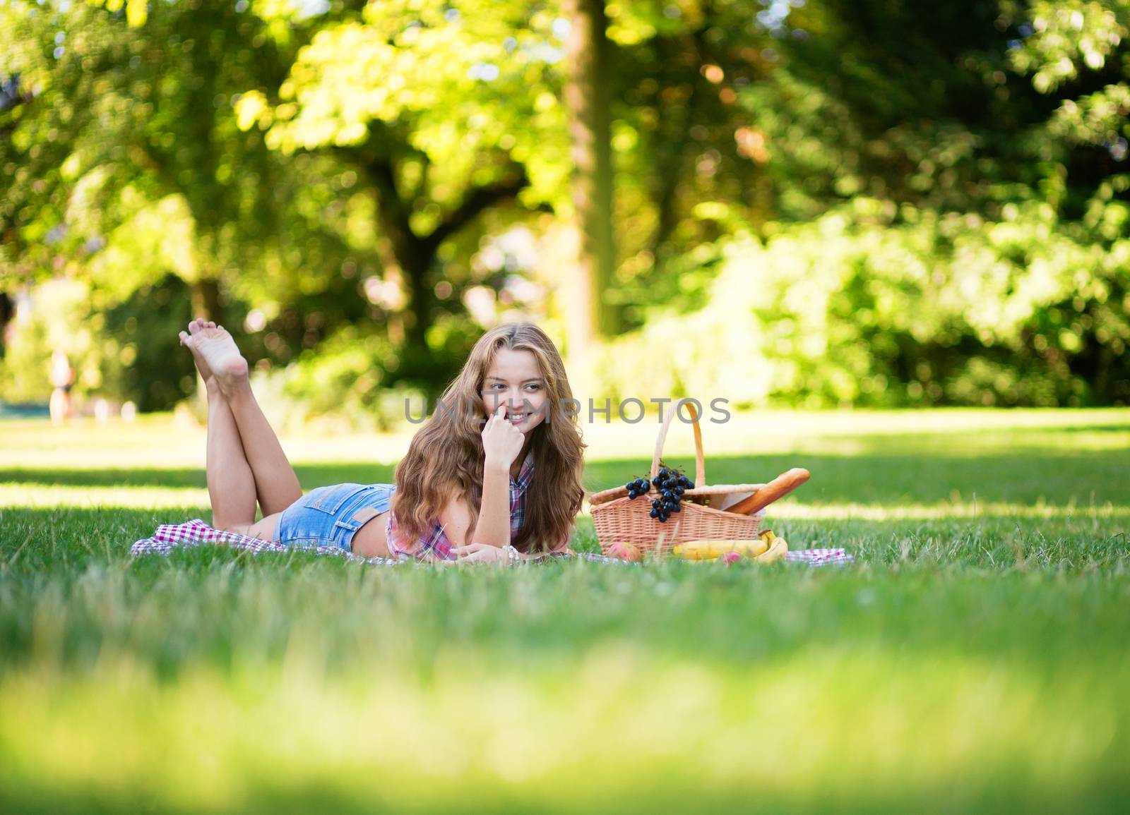Beautiful young girl having a picnic in park