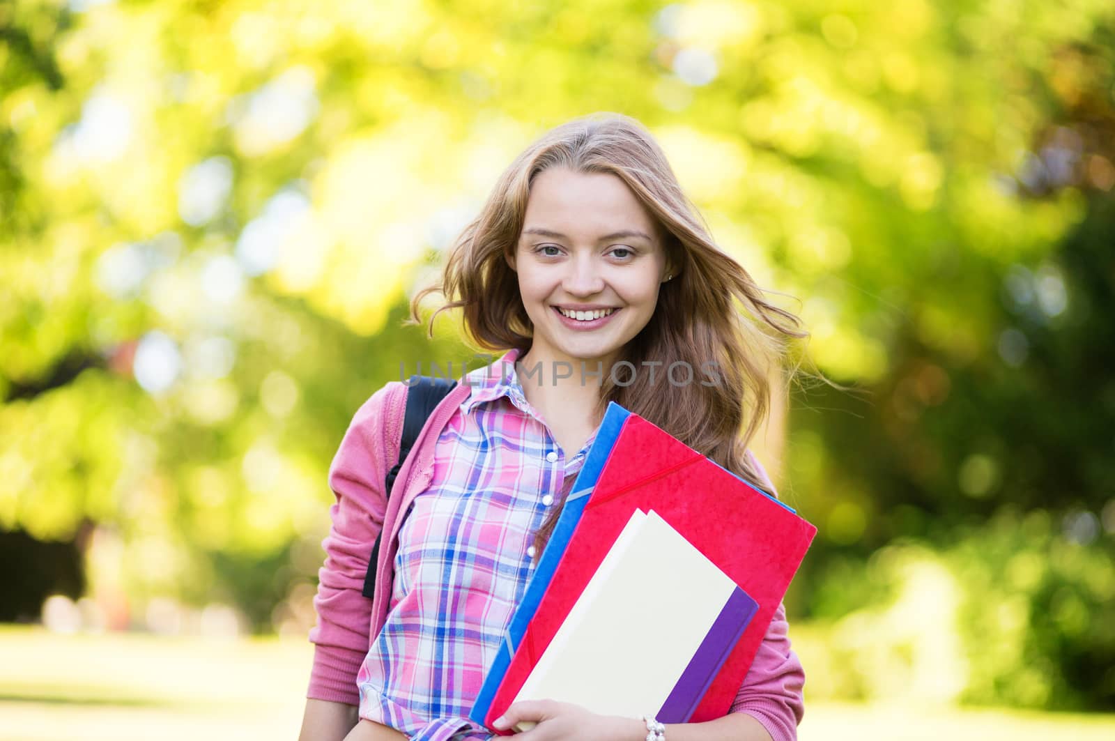 Student girl outdoors going back to school and smiling