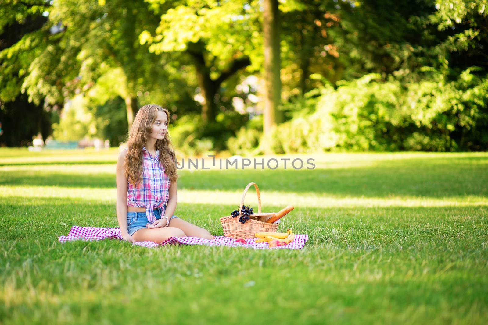 Young pretty girl having a picnic in park