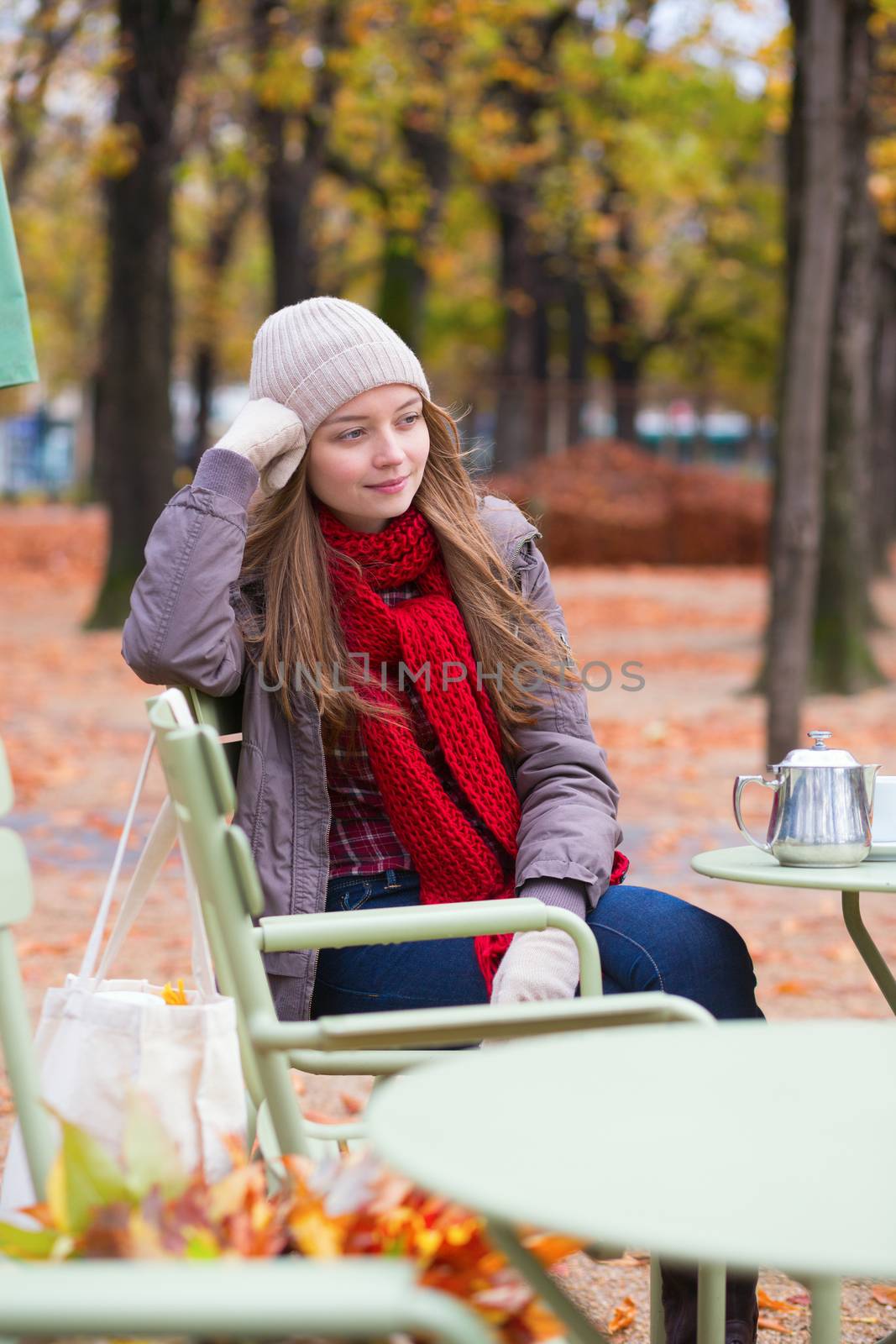 Young beautiful girl in an outdoor cafe on a fall day