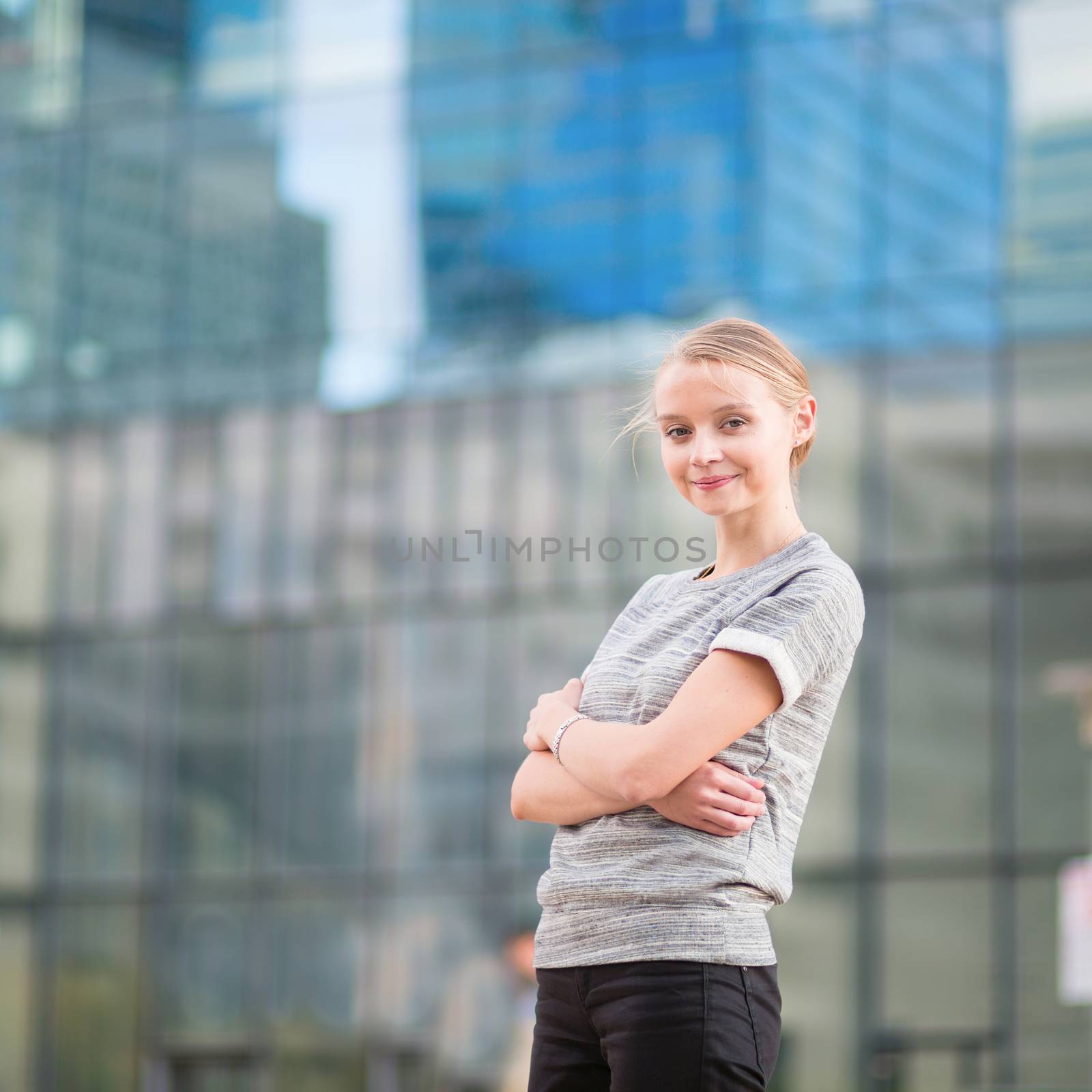 Smiling young woman in modern glass office interior