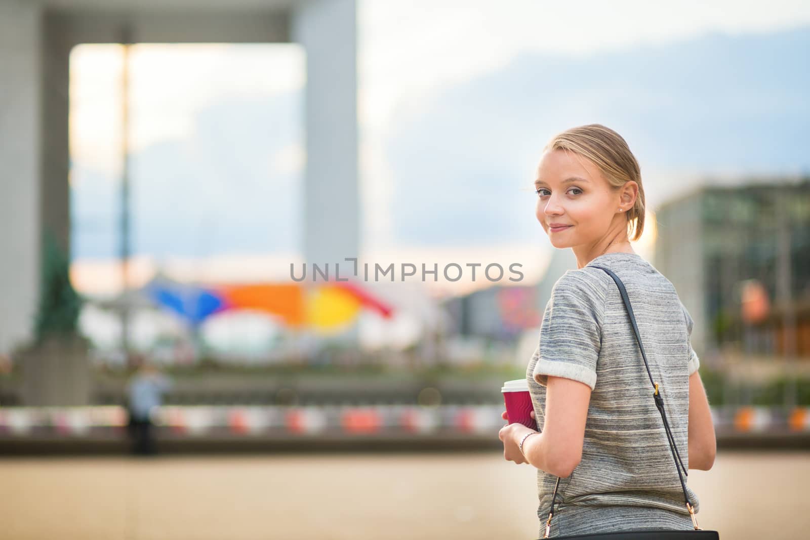 Young beautiful business woman or student drinking coffee outdoors