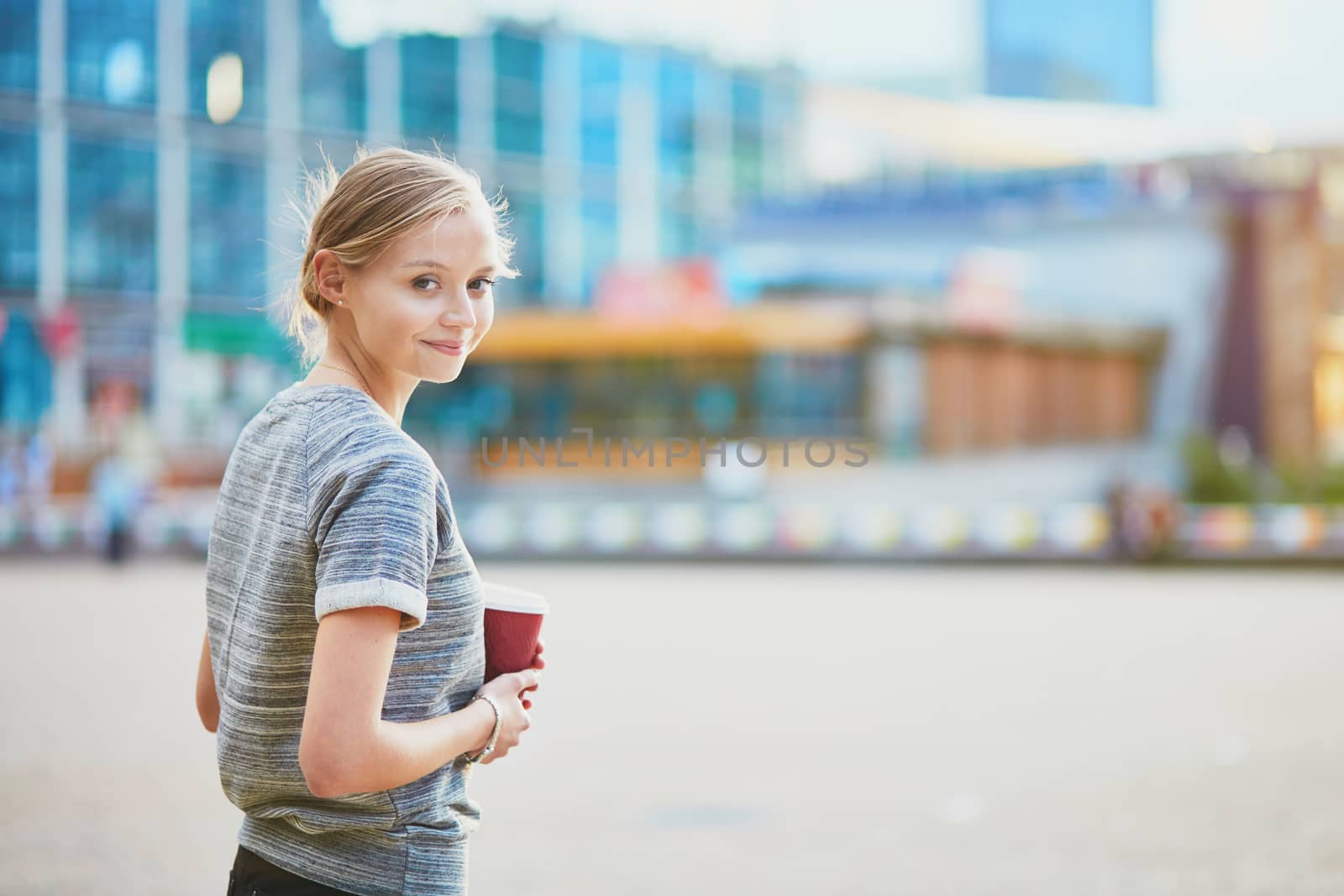 Young beautiful woman having her coffee break outside of the office or university