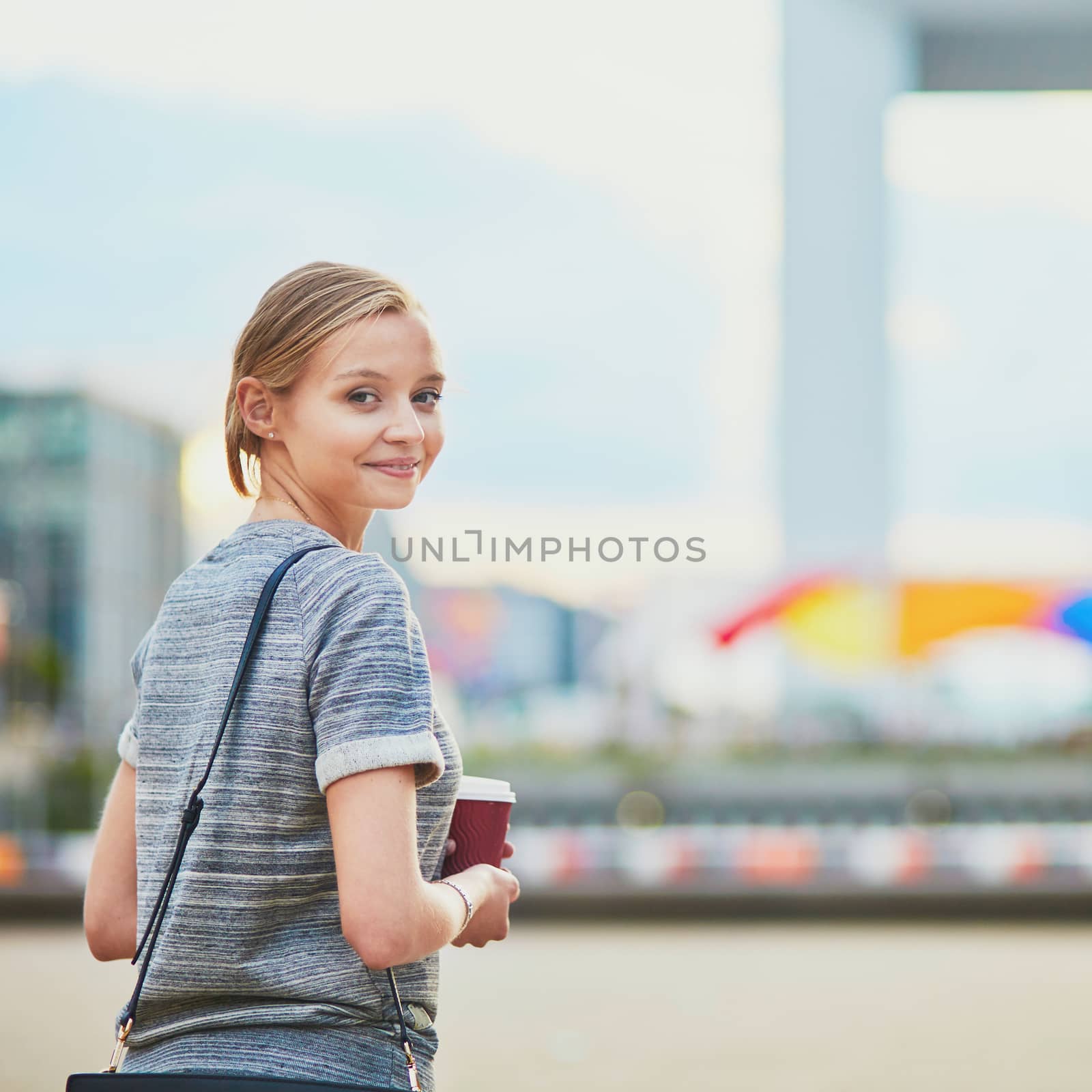 Young beautiful woman having her coffee break outside of the office or university