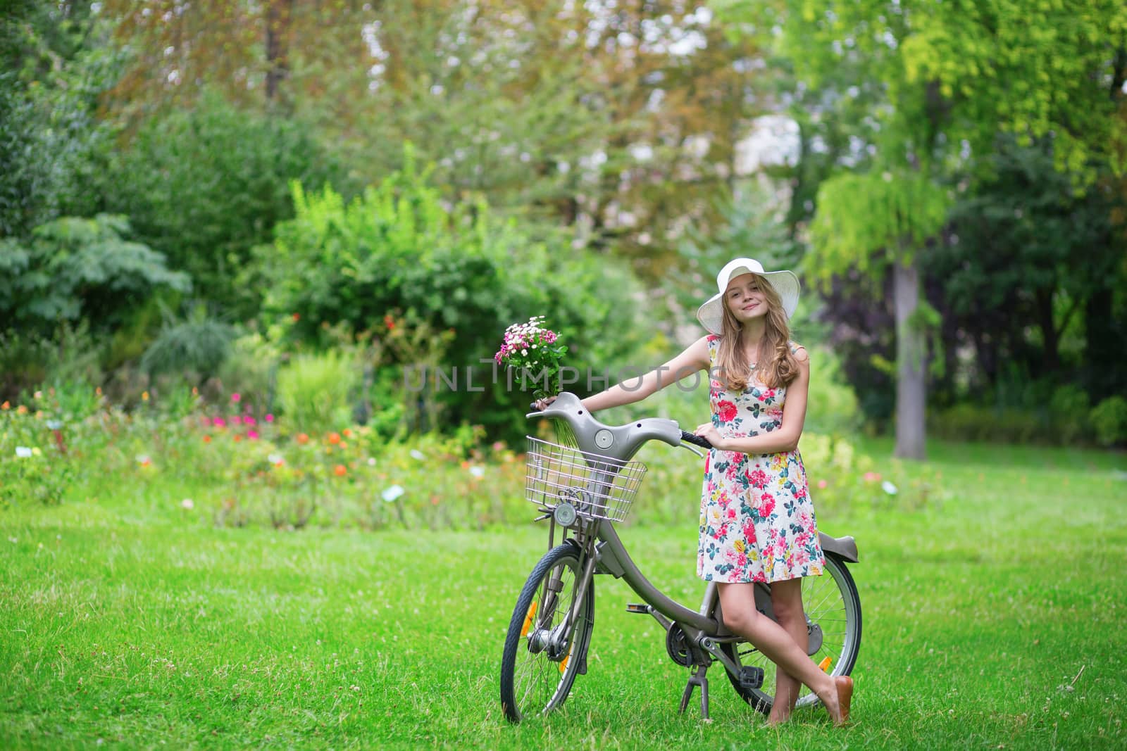 Beautiful young girl with bicycle in the countryside