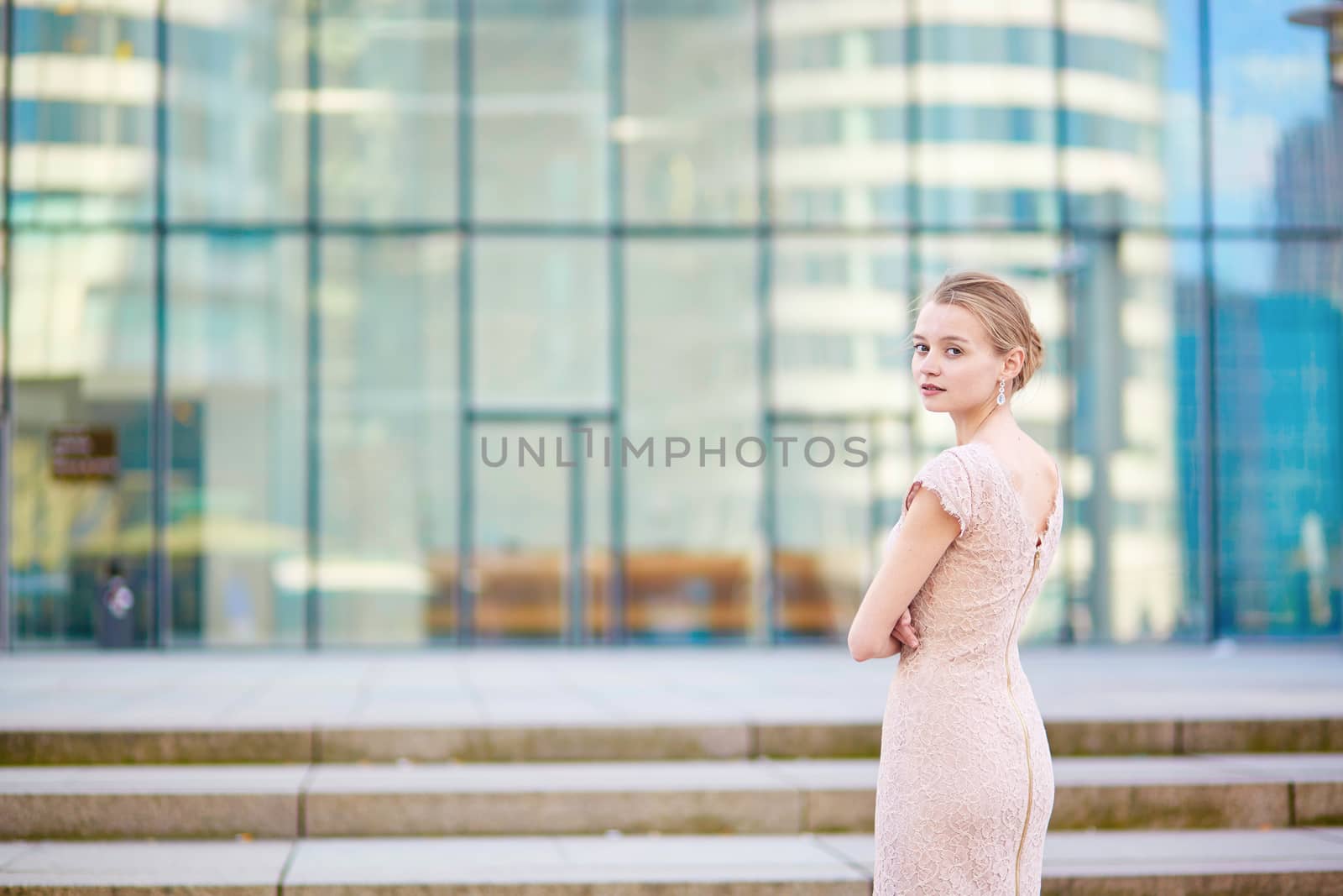 Beautiful young business woman in modern glass office interior