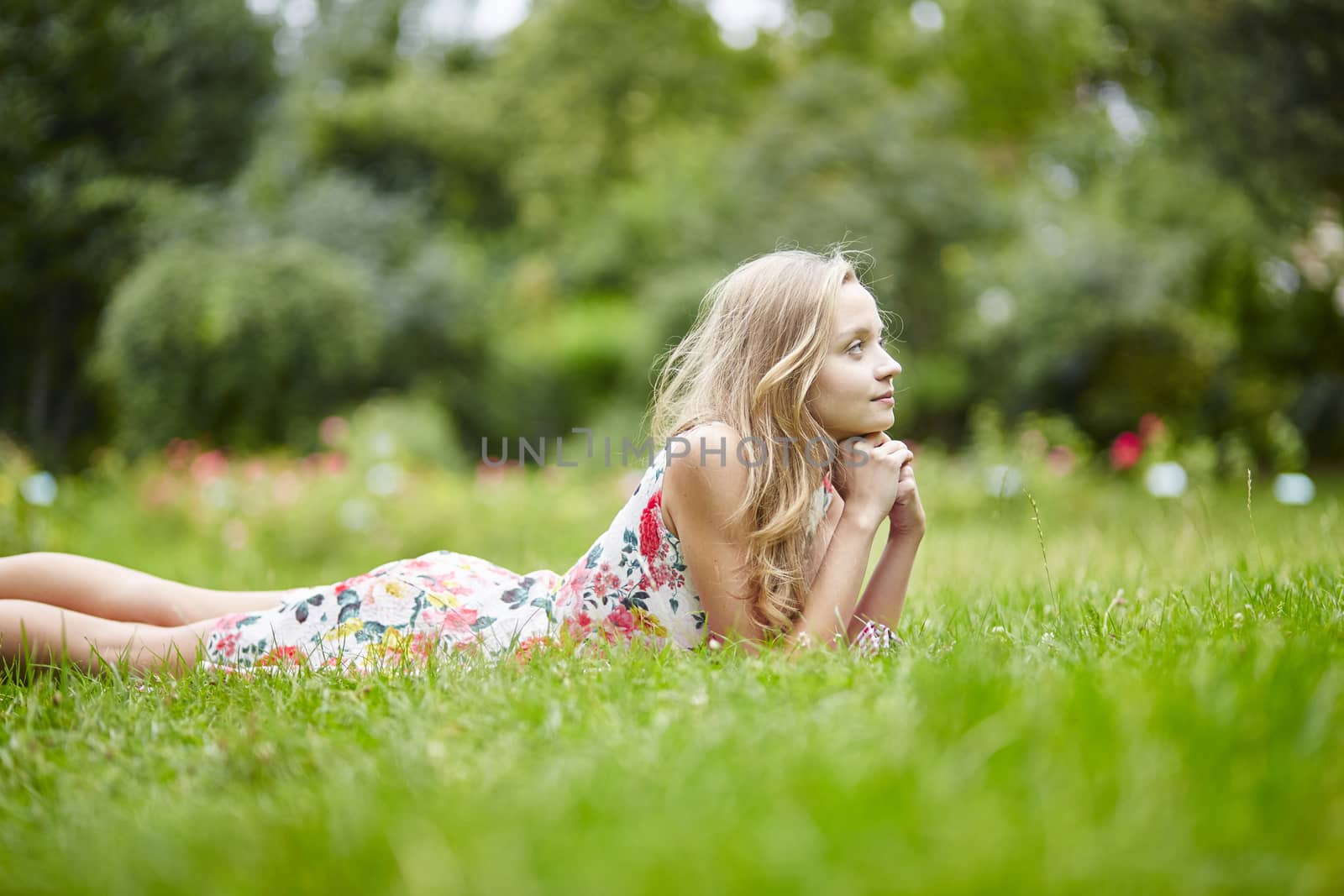 Beautiful young girl lying on the grass on a summer day 