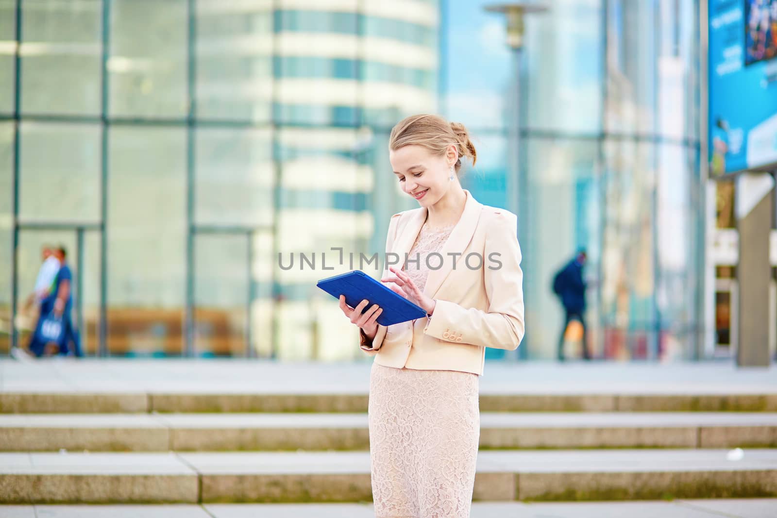 Beautiful young business woman in modern glass office interior